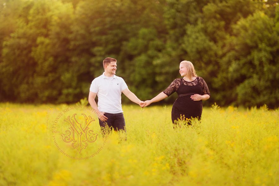 Loving maternity photo of couple in a field of yellow flowers in Oconee County, GA.