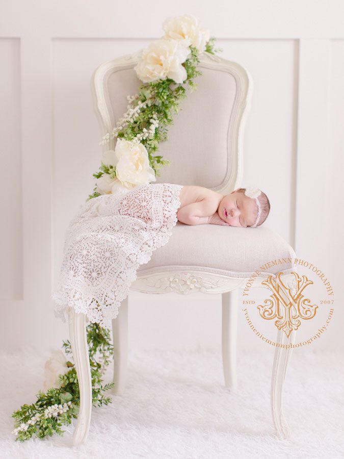Newborn beauty on chair with flower garland taken by Fine Art Photographer in Oconee County, GA.