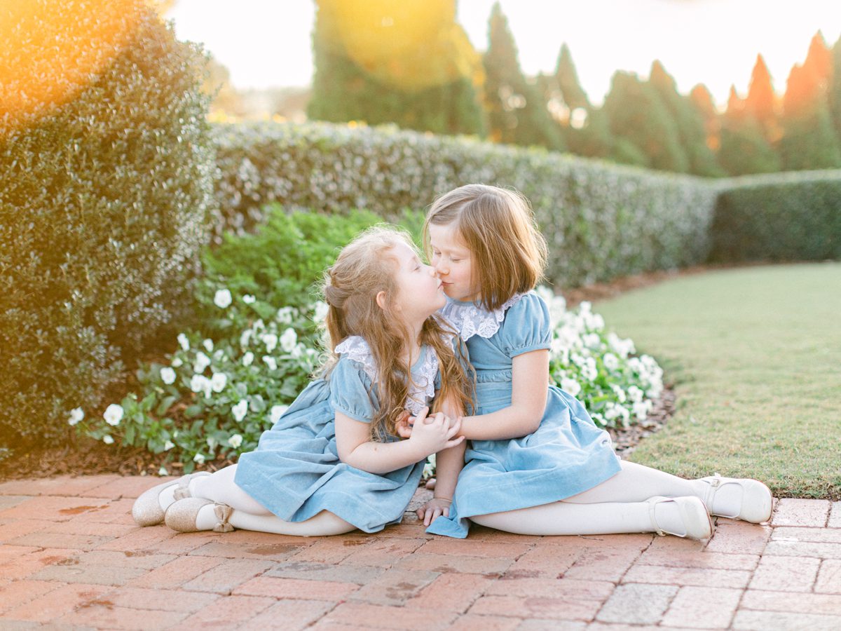 Sisters kissing children's Christmas photoshoot at Georgia Club