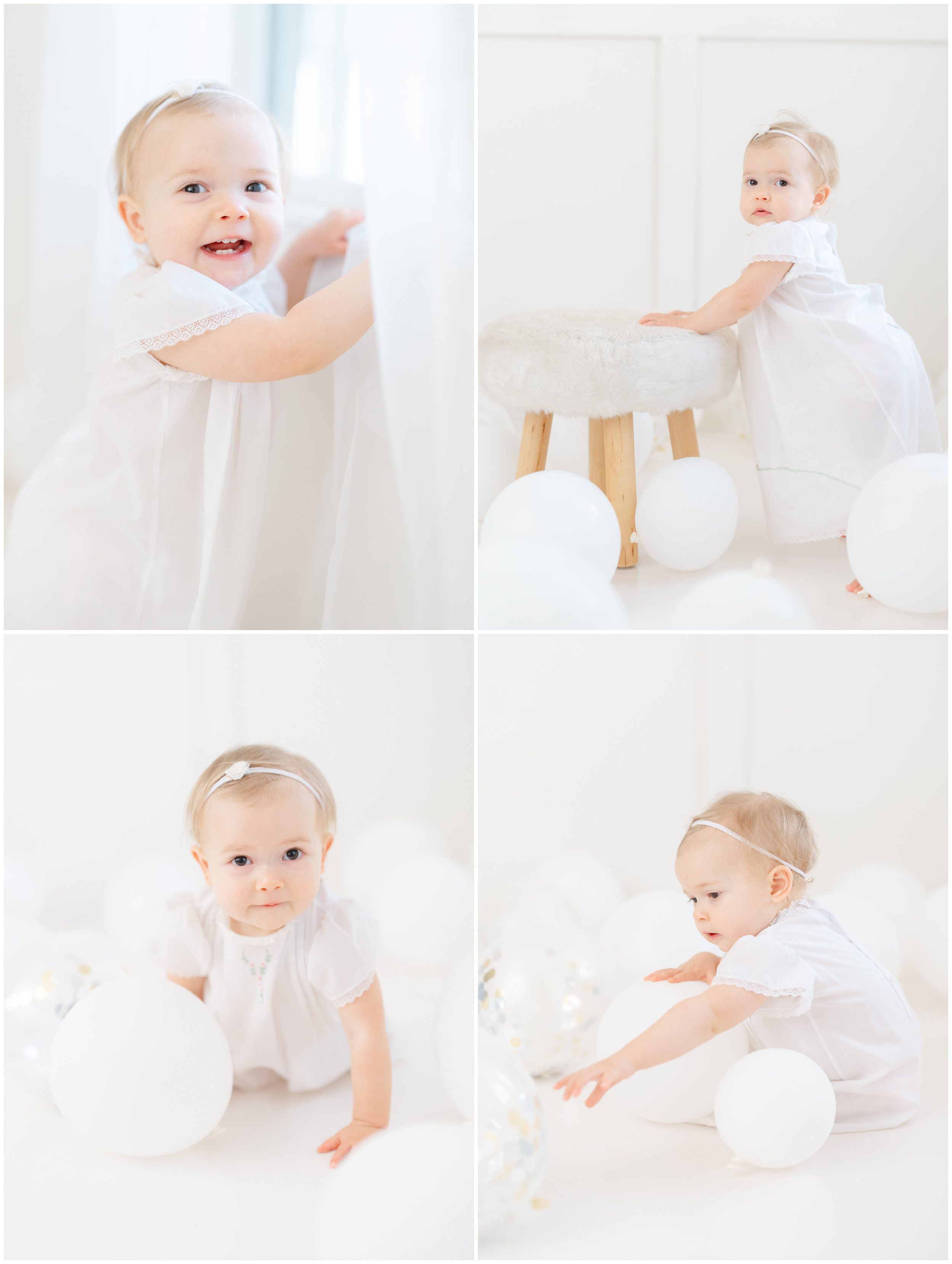 Baby girl celebrating her first birthday with white balloons in a bright studio