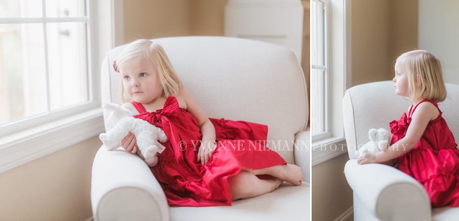 Bishop, GA lifestyle children's photography of a 2 year old on a chair with her lamb looking out the window.