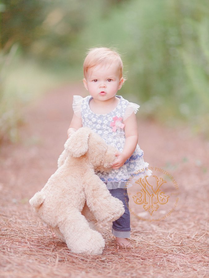 Athens, GA outdoor baby photography of a one year old with her stuffed bunny in a wooded pathway.