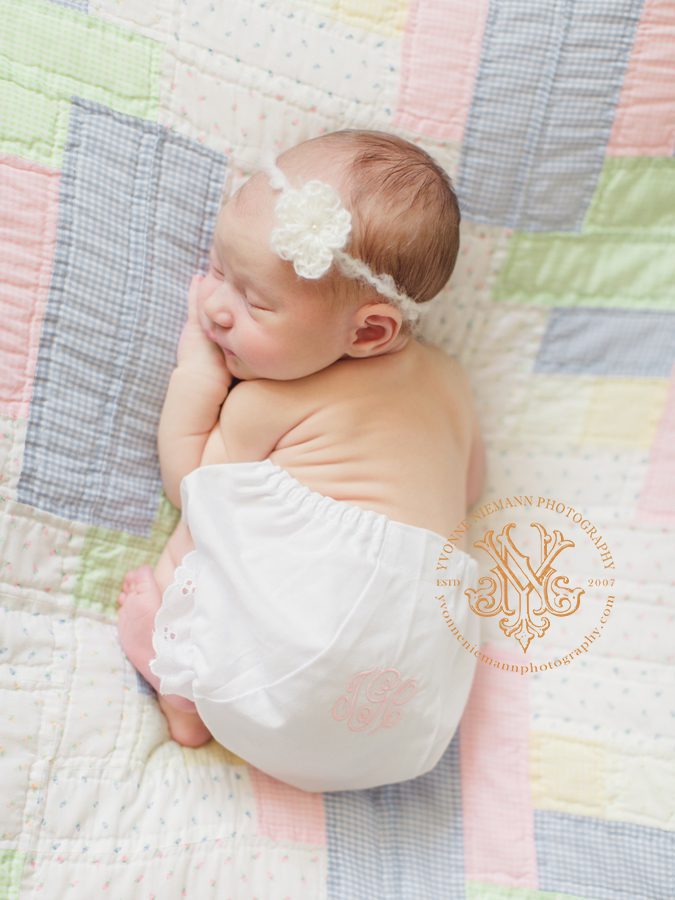 photo of an eleven day old newborn girl in monogramed bloomers on family heirloom quilt