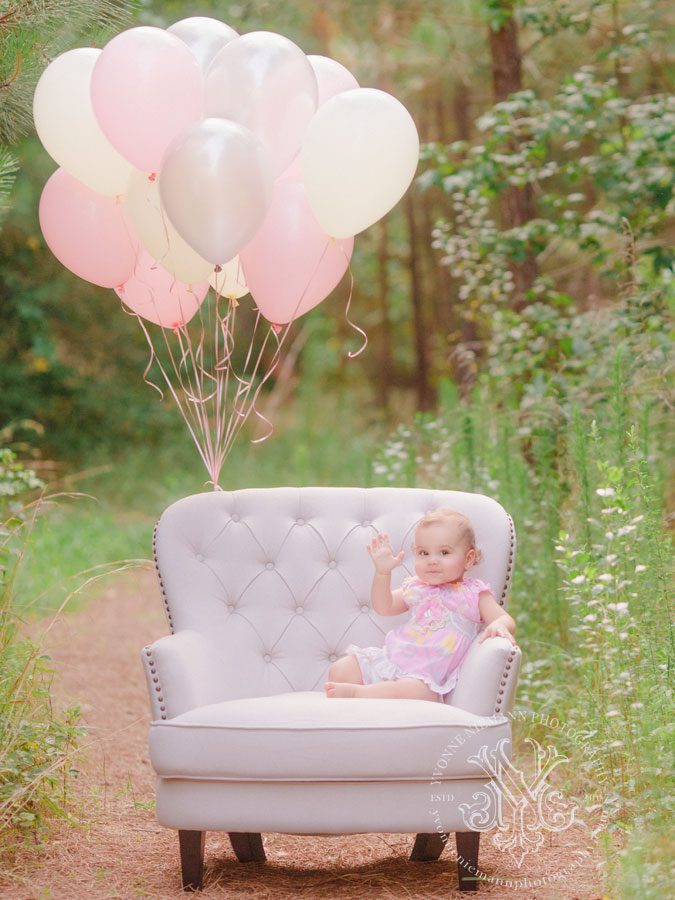 Baby's first birthday portrait in Bishop, GA with balloons in the woods.