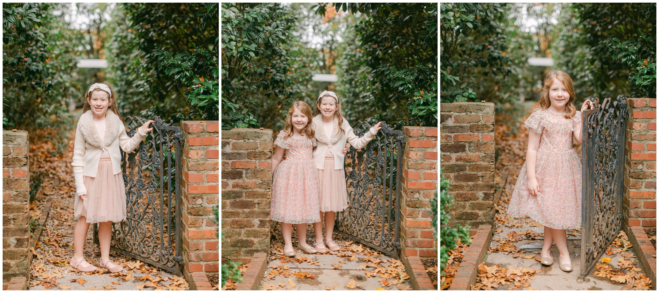Two sisters in soft pink and cream dresses posing by a decorative iron gate framed by brick columns and fall greenery.