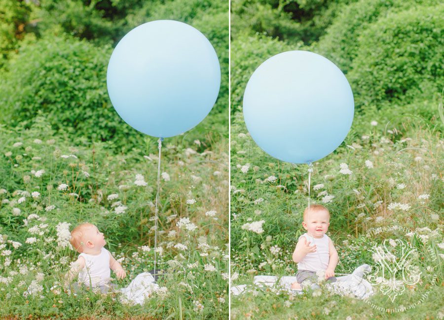 First birthday baby outdoor photography with a giant blue balloon surrounded by field of white flowers in Athens, GA.