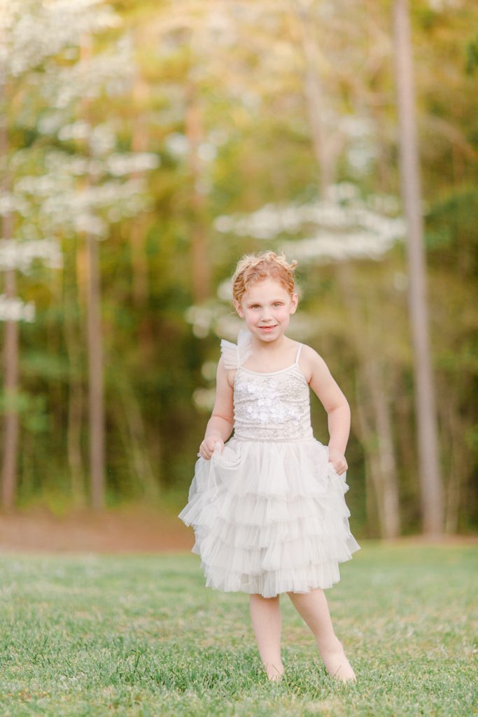Spring professional children’s photography taken in Oconee County, GA of a little girl with flowering dogwood trees