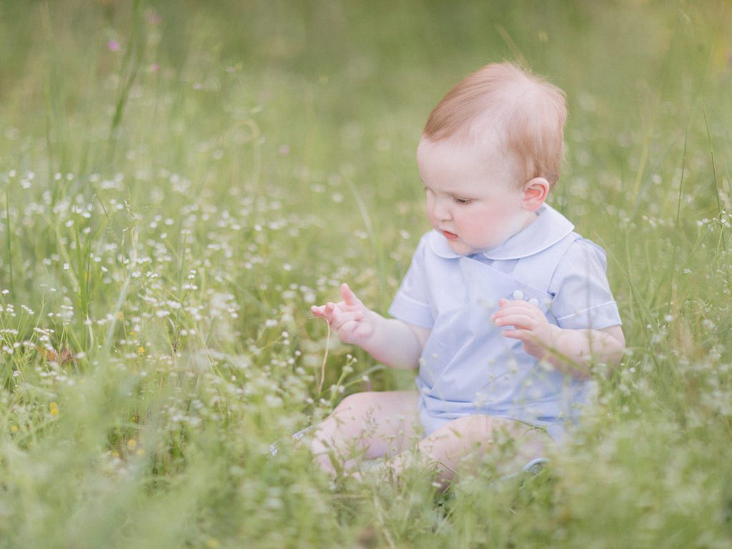 baby's sitting milestone photo in a field of white flowers in Watkinsville, GA.