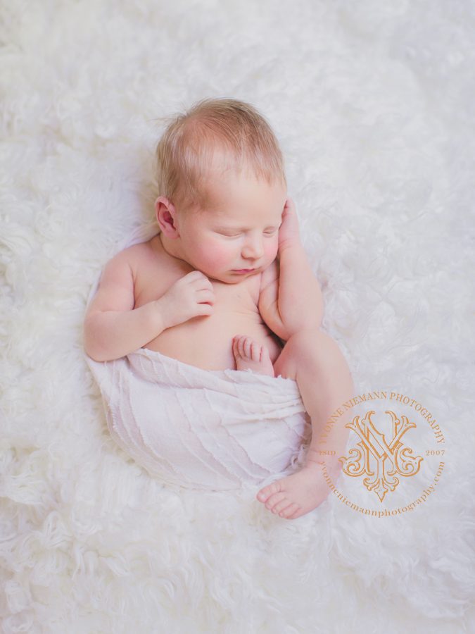 two week old infant boy sleeping swaddled like in the womb in Watkinsville, GA