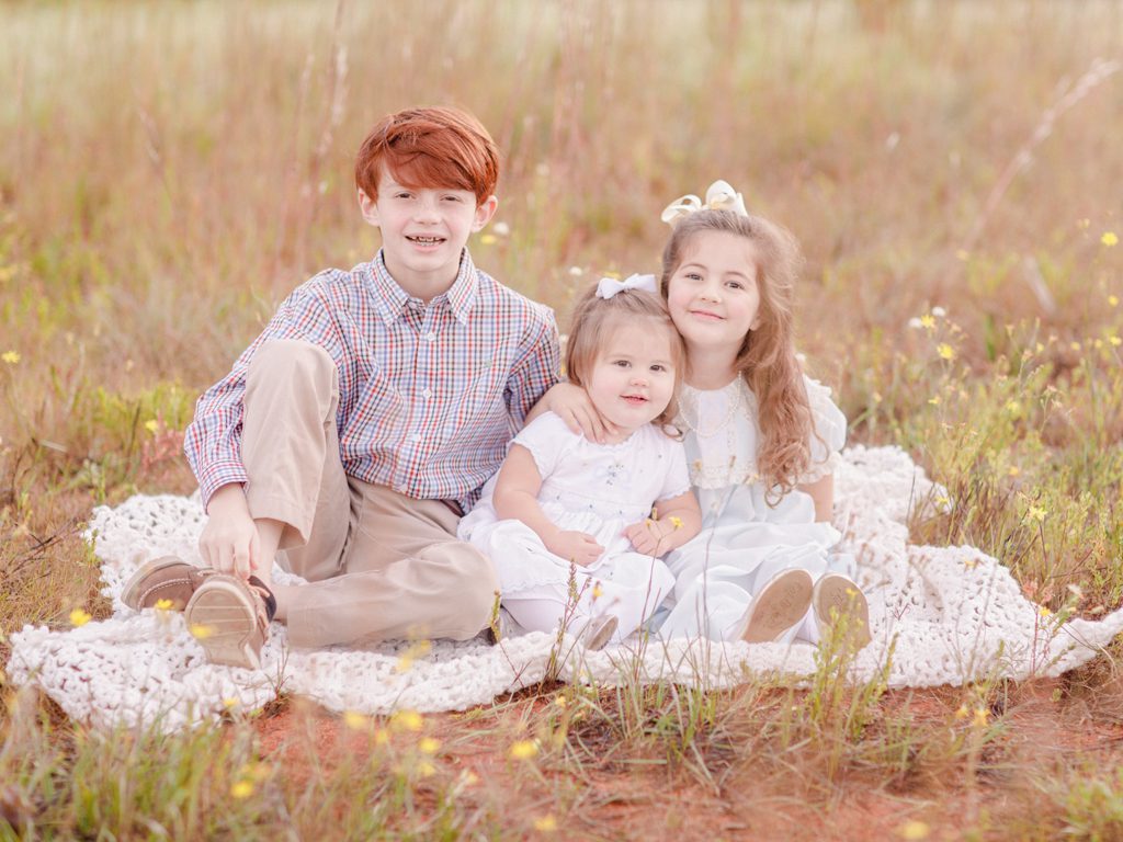 Athens GA childrens photographer takes sweet portrait of three siblings in a field in Oconee County.