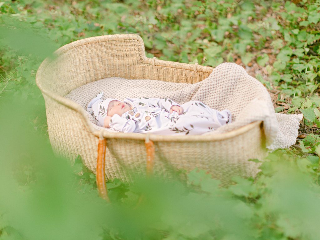 Outdoor newborn photography of a one week old in a Moses basket in Bishop, GA.