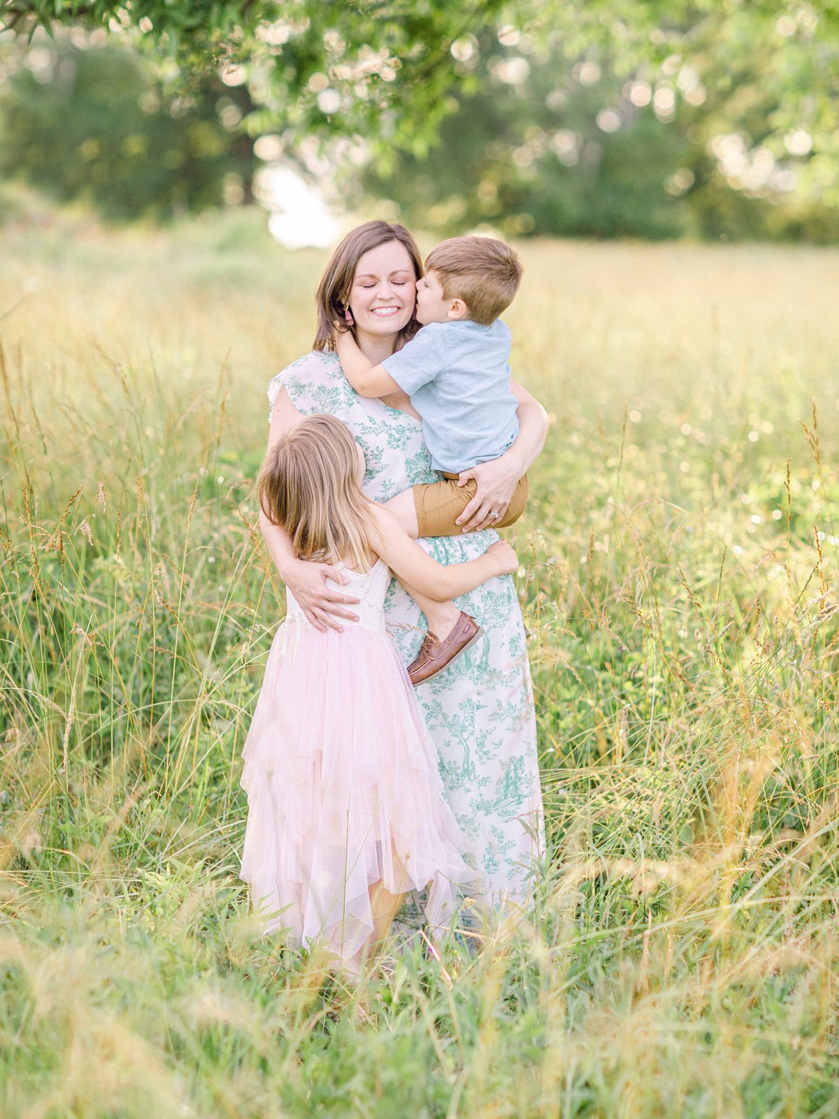 Motherhood lifestyle photography of a mom with her two young children in a field in Watkinsville, GA.