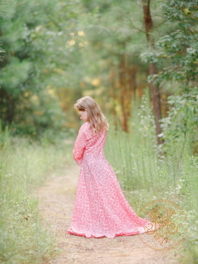 Serene fine art portrait of a little girl in long flowing gown in the woods in Bishop, GA.