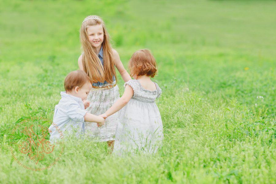 Children playing ring around a rosy in field in Oconee County taken by Yvonne Niemann Photography.