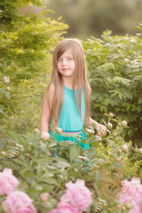 Portrait of a five year old little girl surrounded by peonies and greenery taken by Yvonne Niemann Photography in St. Charles, MO.