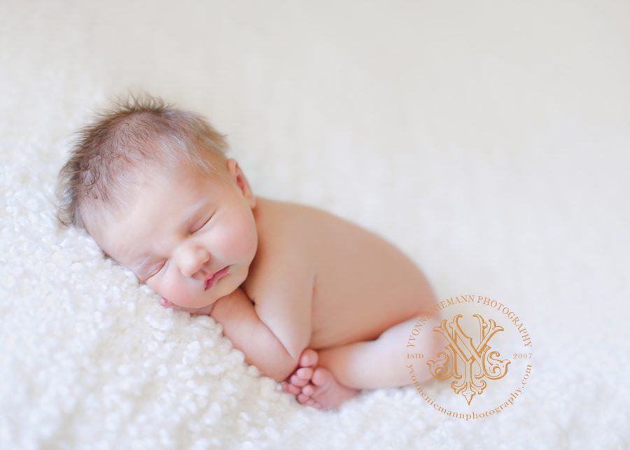 Natural newborn portrait on a cream blanket taken by Athens, GA newborn photographer, Yvonne Niemann Photography.