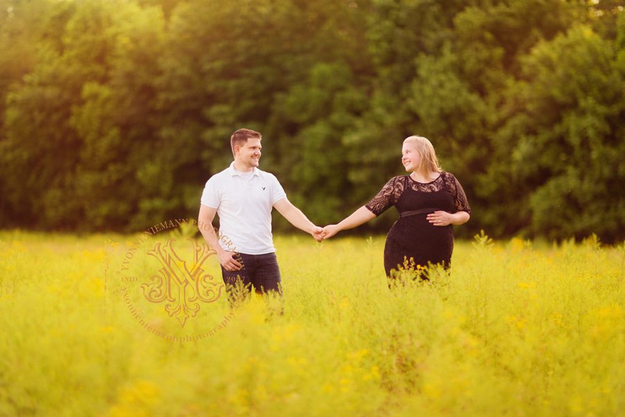 photo of couple holding hands in a field of mustard flowers in Florissant, MO taken by Yvonne Niemann Photography